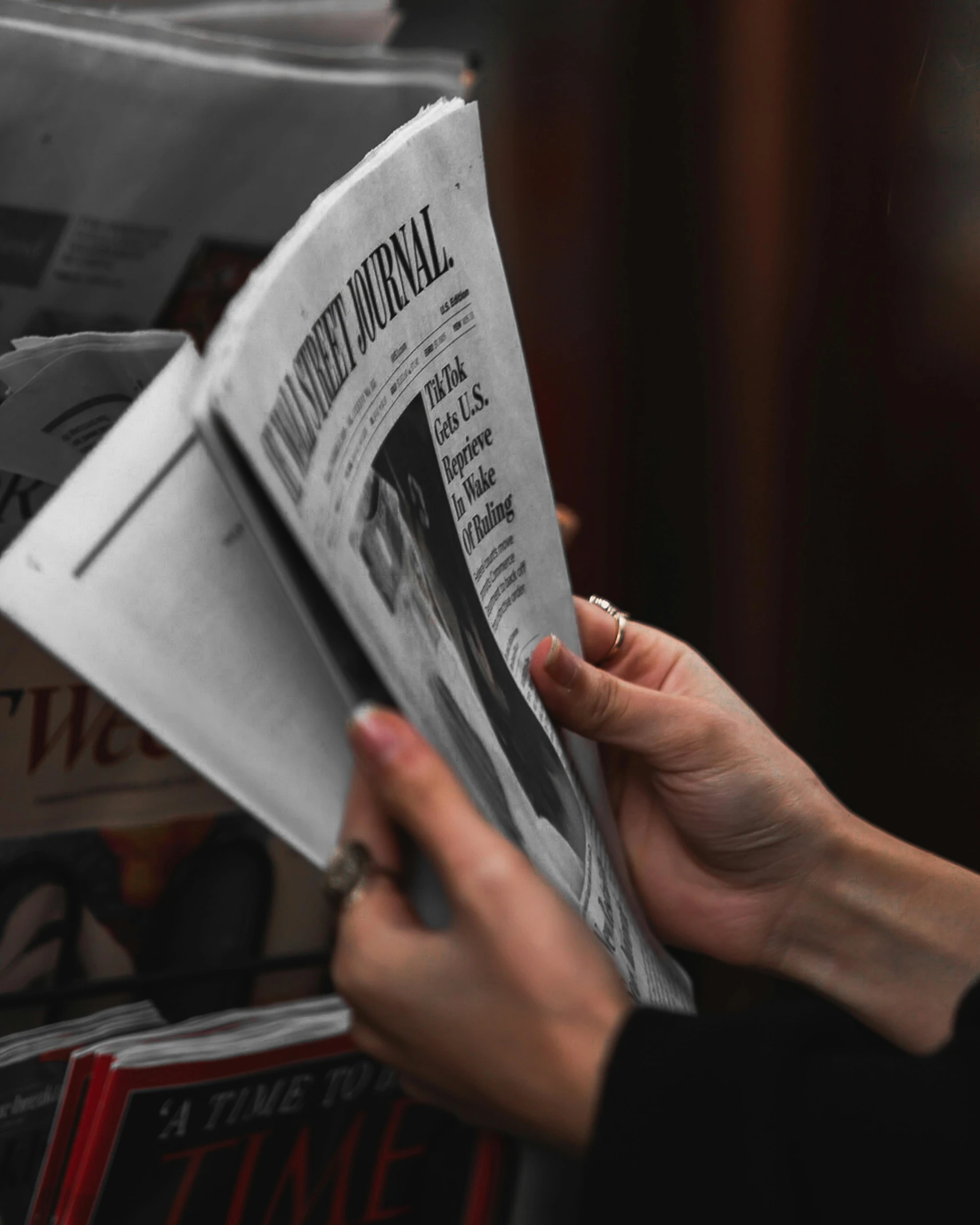 someone holding a magazine with their hand up in the air