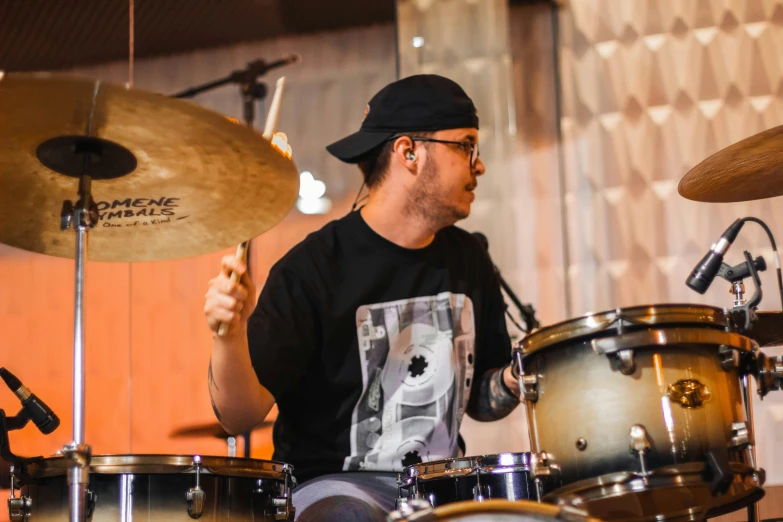 a man plays drums with a sticker on his back