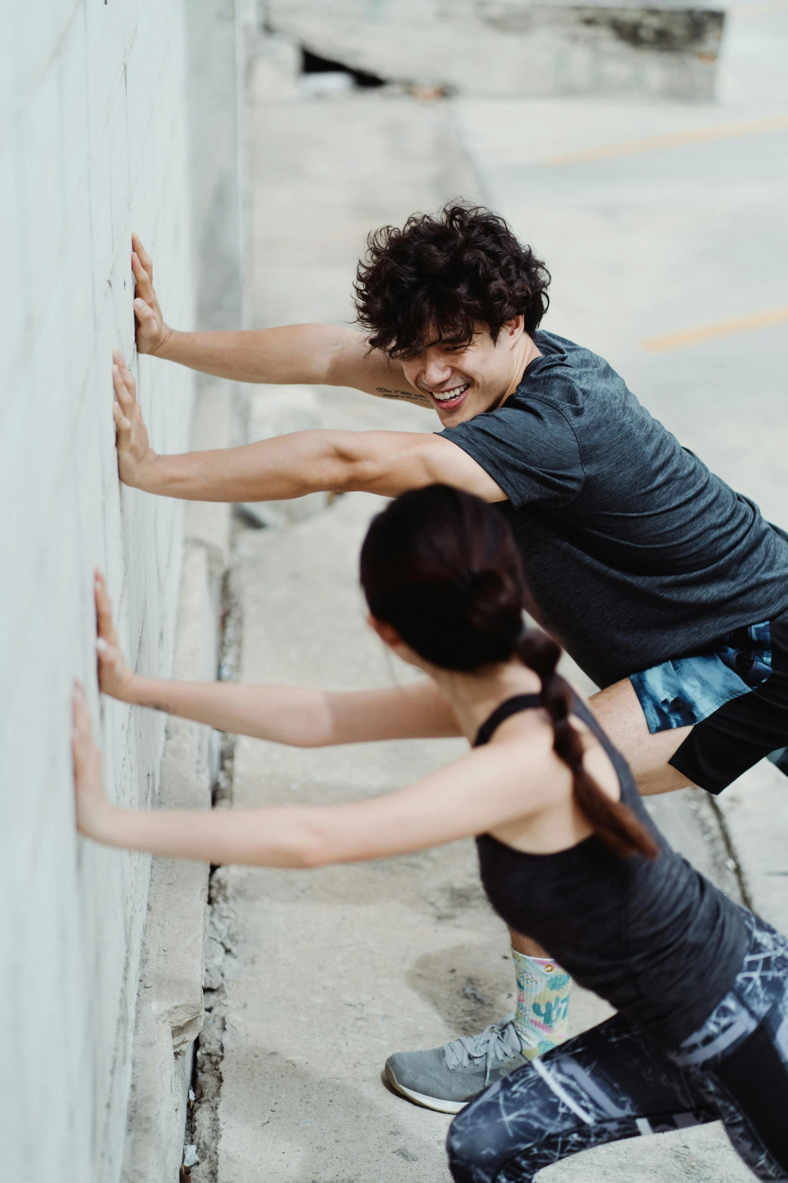 two women standing near a wall doing soing