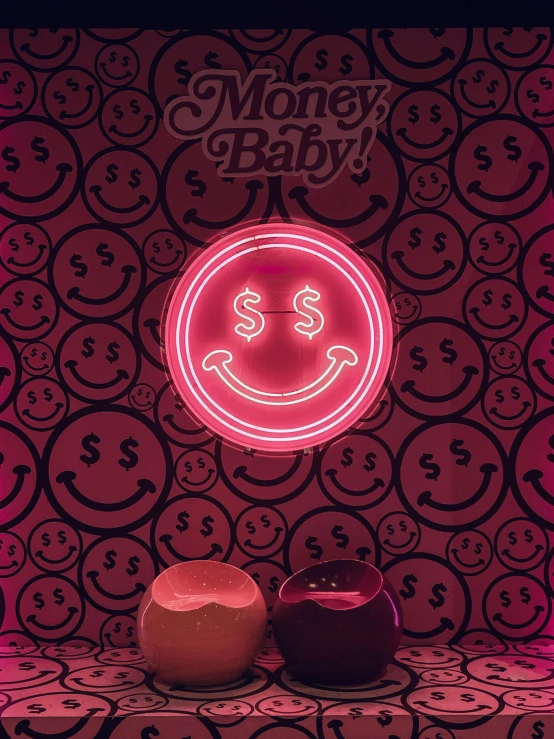 money bag neon sign and two cups displayed in front of the wall