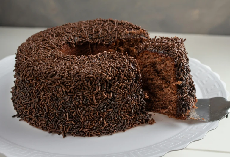 the chocolate cake is on a plate next to a knife