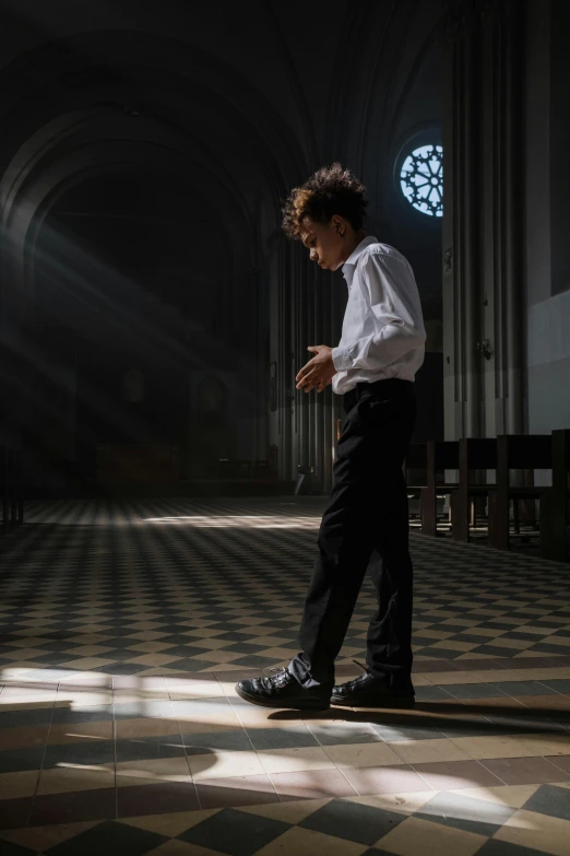 a young man standing in front of a church while texting