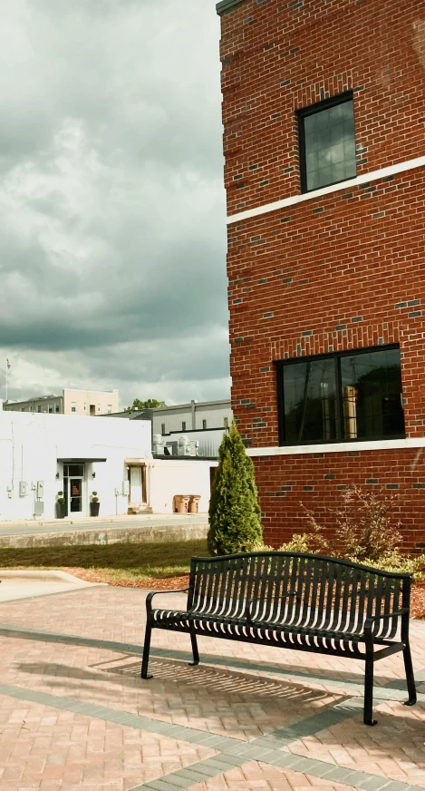 a bench sits in front of a brick building