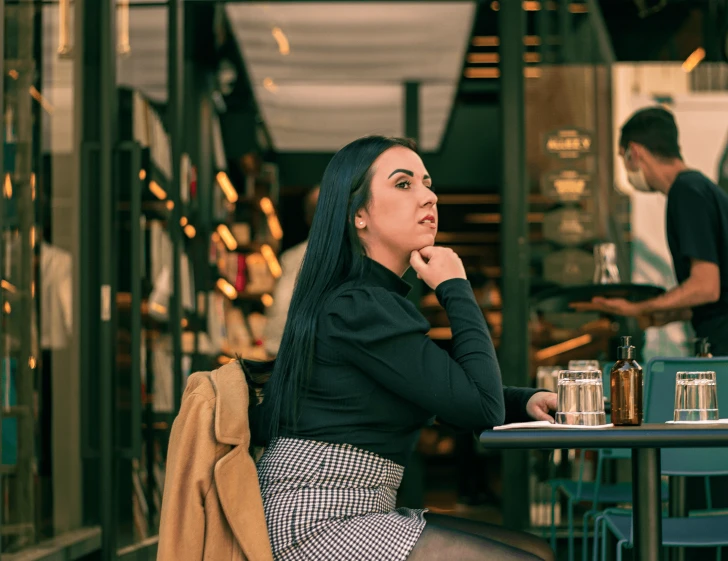 woman in black dress sitting at table looking at man