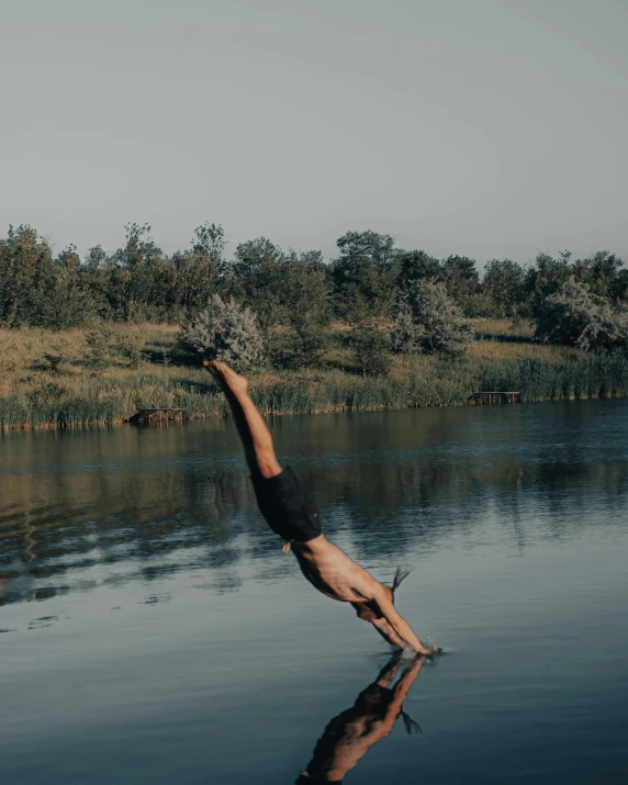 a man dives into the water with his arms outstretched