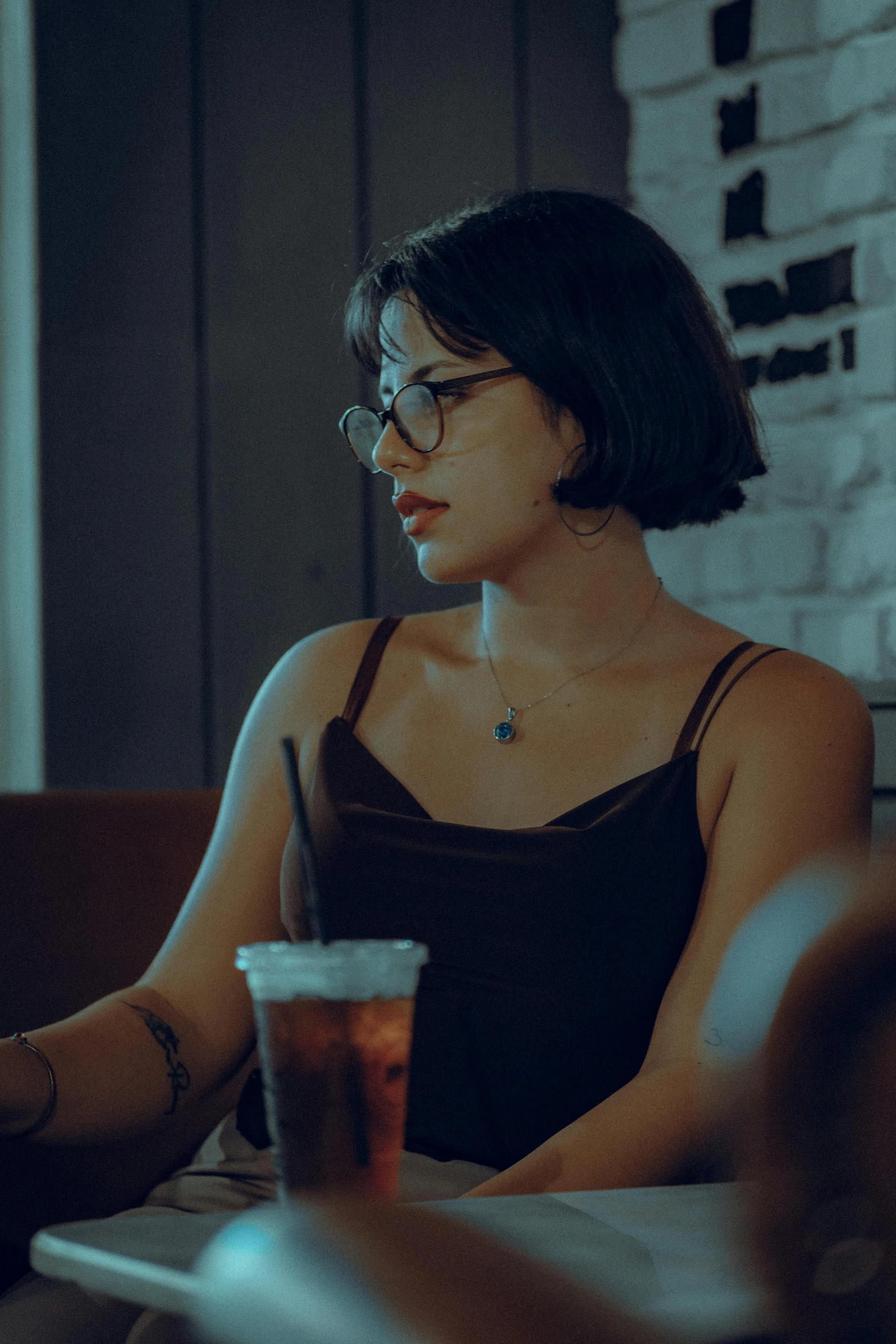 a woman with glasses using her laptop at a table