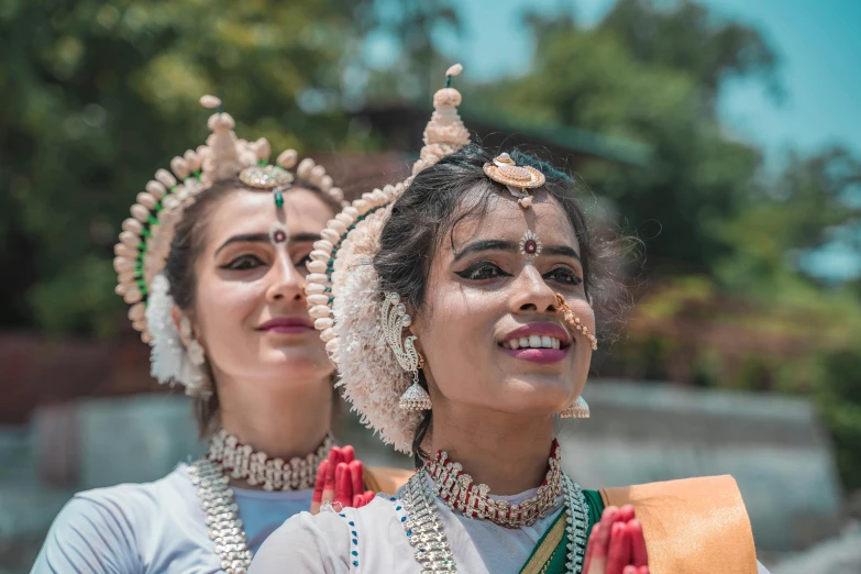 two indian women in costume standing and smiling