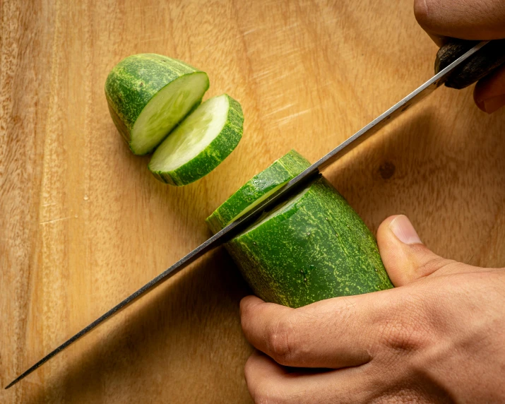 person  up cucumber on a wooden table