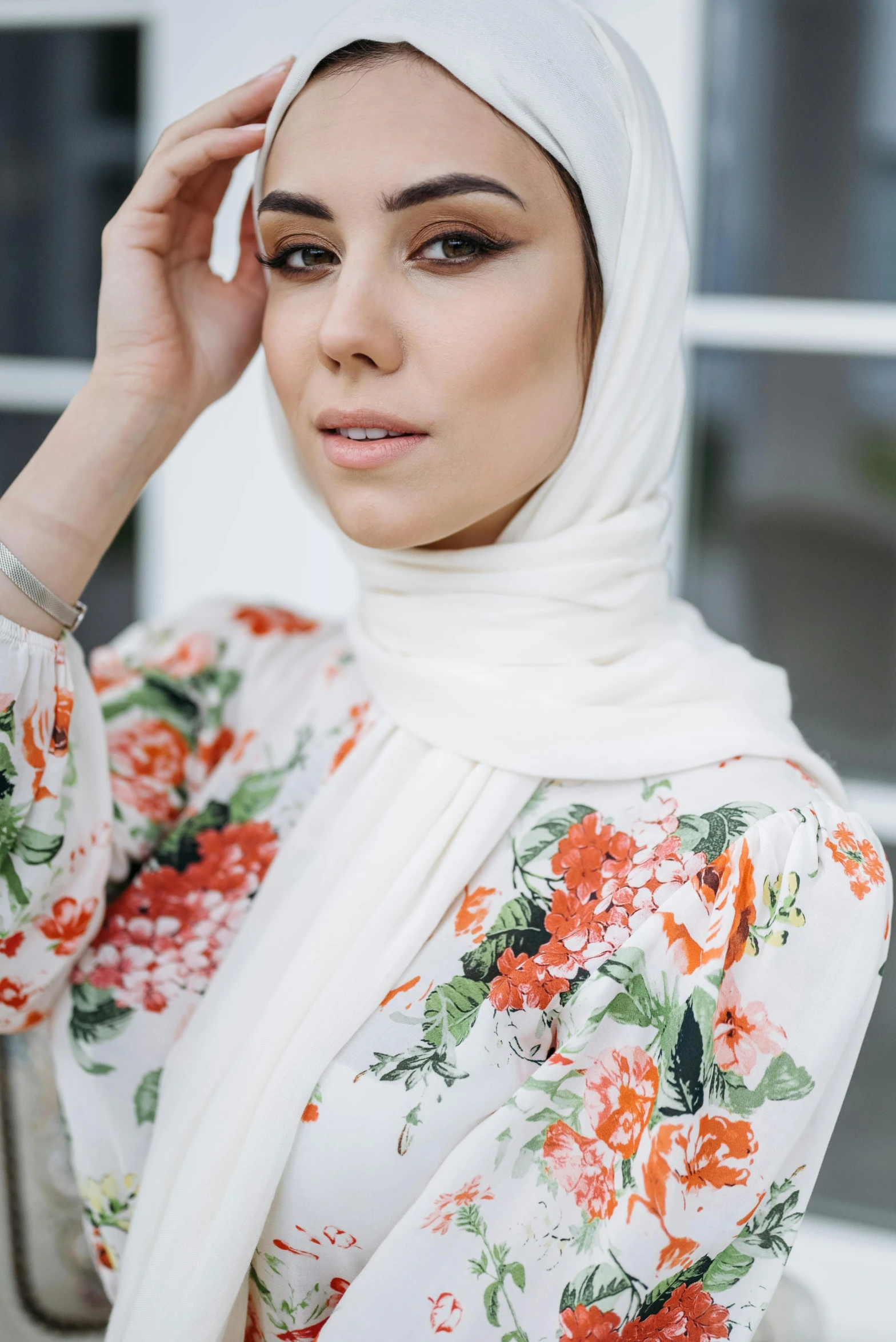 a woman wearing a floral top and head scarf