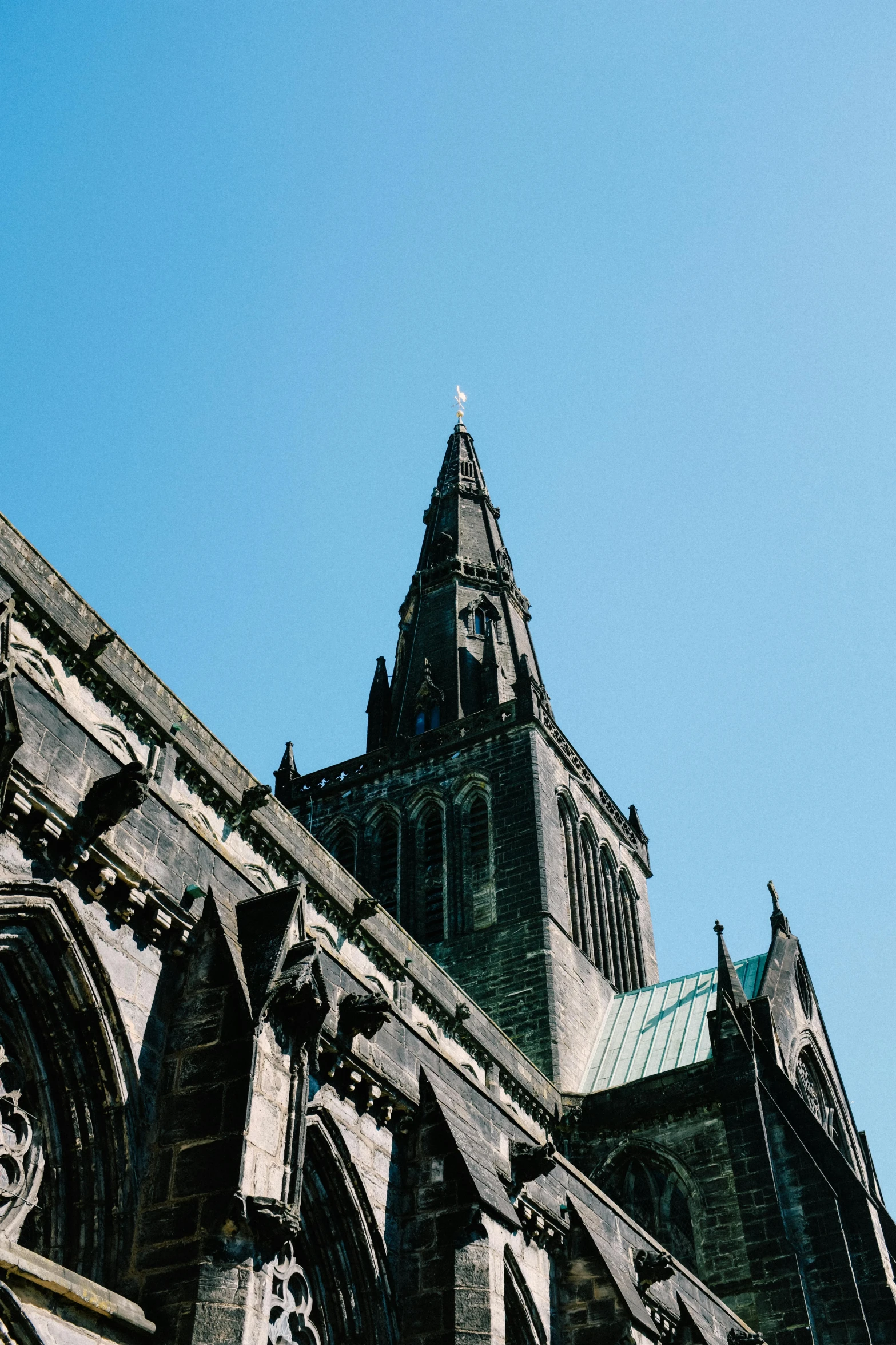 the top of an old cathedral tower against a clear blue sky