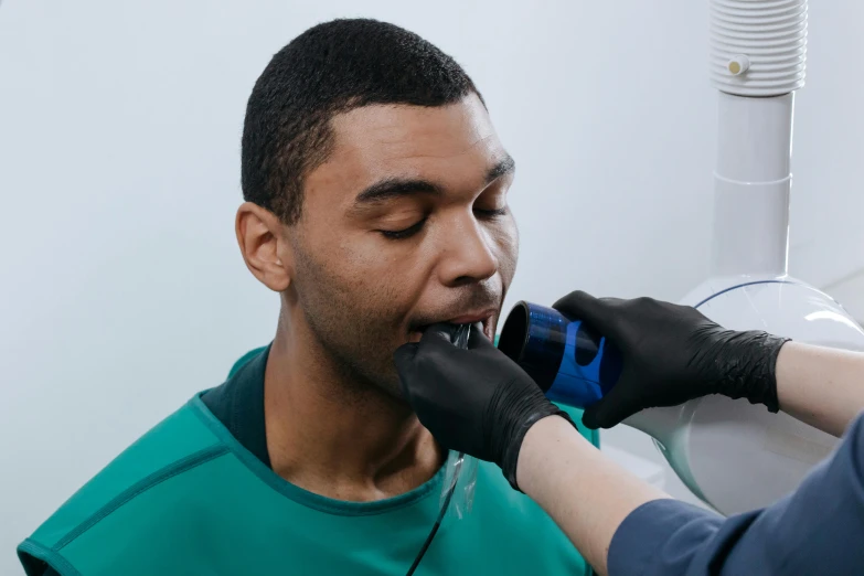 a person is trimming another persons hair with gloves