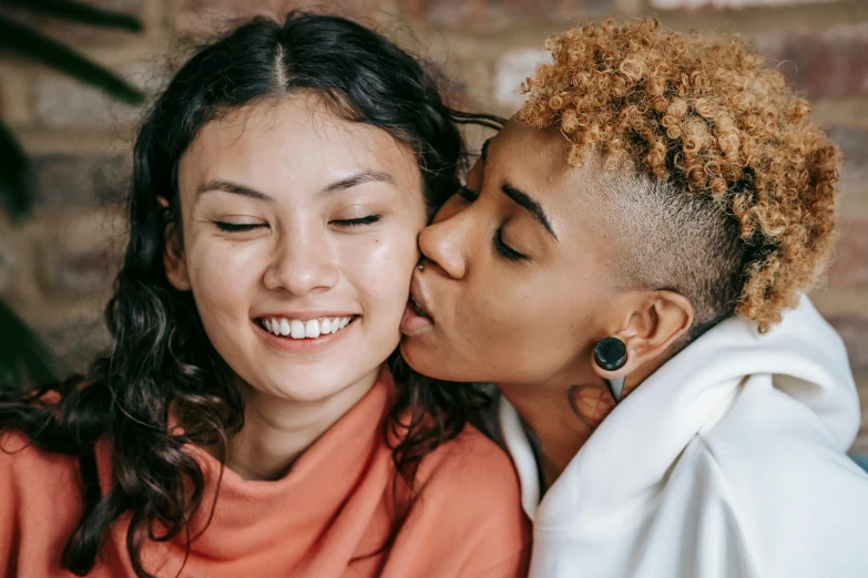 two girls with frizzy afro hair kissing each other