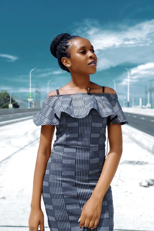 a woman in a black and white dress and a sky background