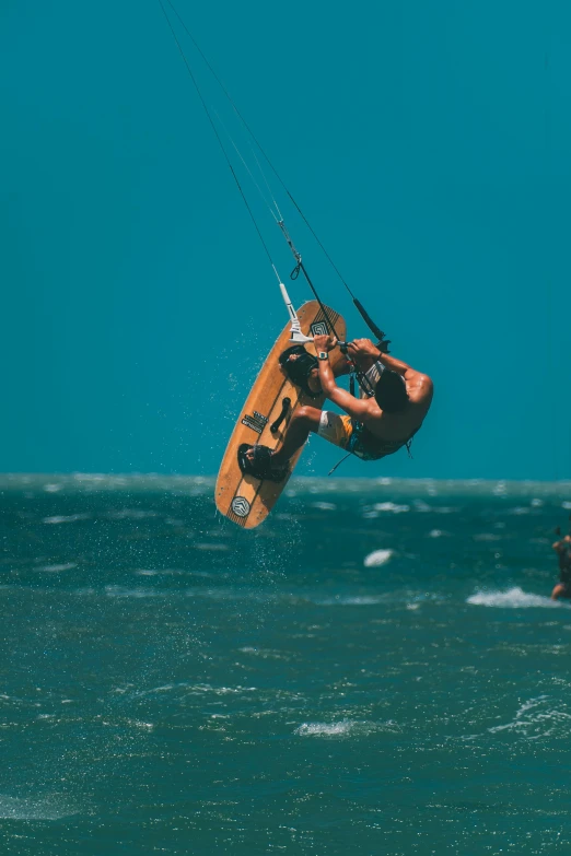 a man in the air while parasailing off shore