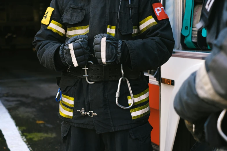 man in fire suit holding up a pair of skis