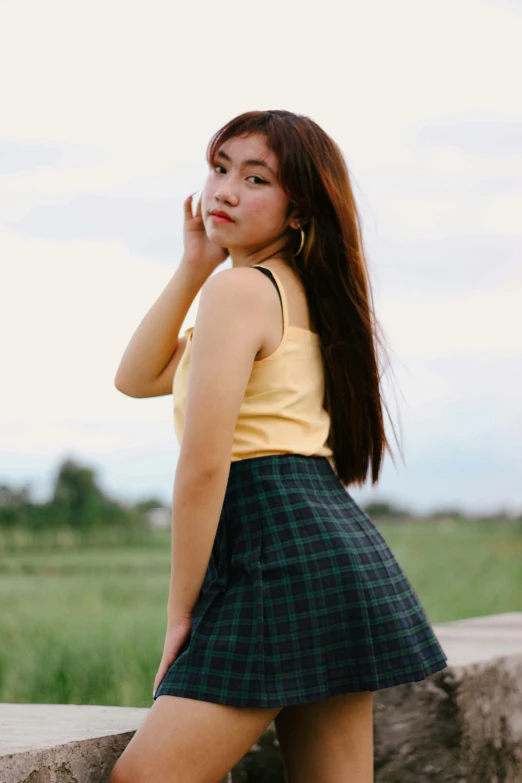 a girl posing on the wall in a skirt