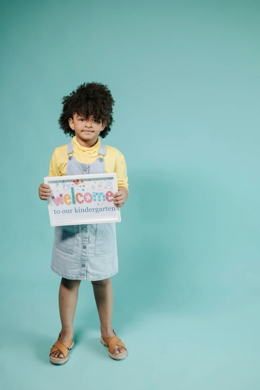 a little girl holding a card in her hands with a message about happiness