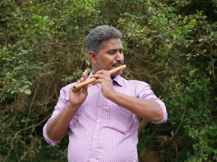 man with flute and mustache in outdoor area