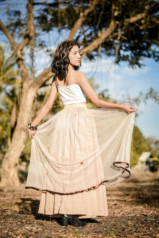 an attractive woman wearing a long dress in the field