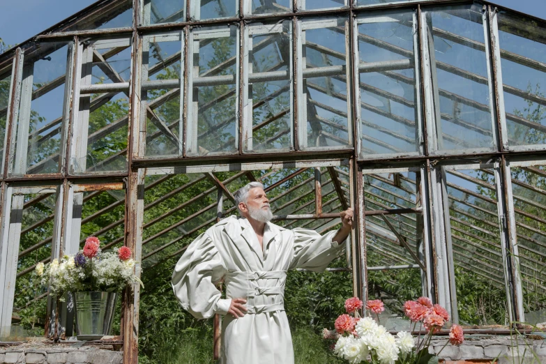 a man dressed up in a priest attire standing outside of a building