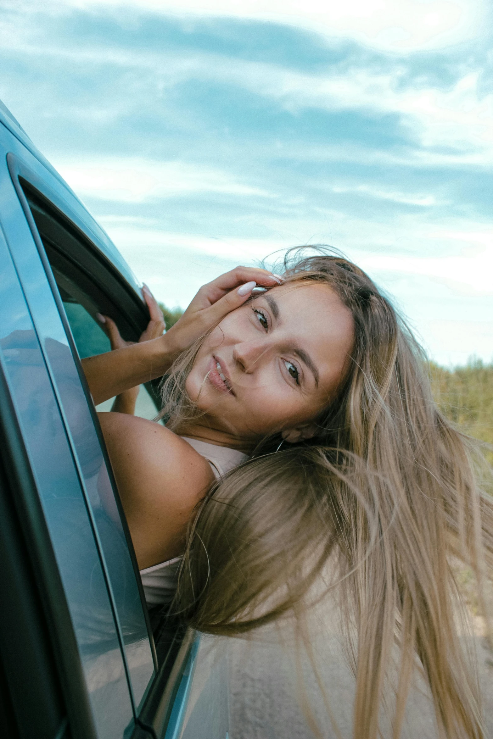 the woman is smiling and leaning against the car's windows