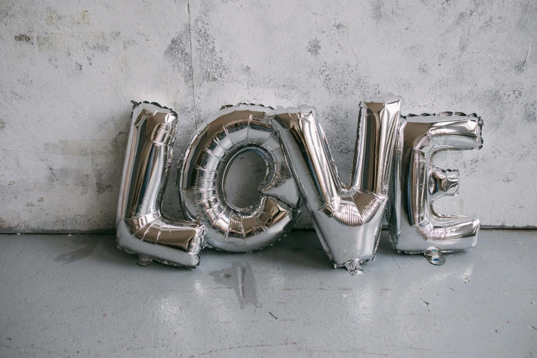 a metal letter sign that says love spelled out of foil