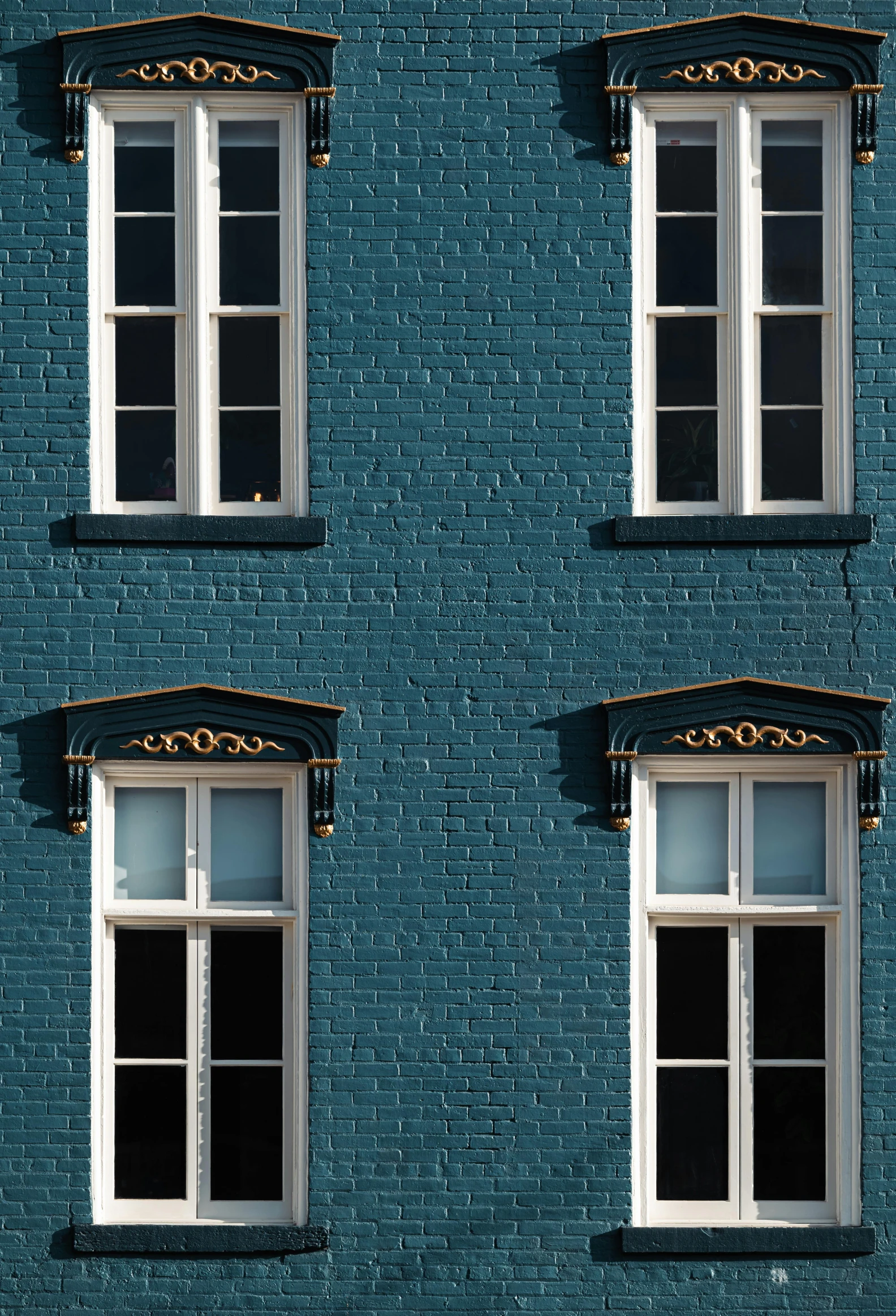 four windows are shown against a blue brick wall