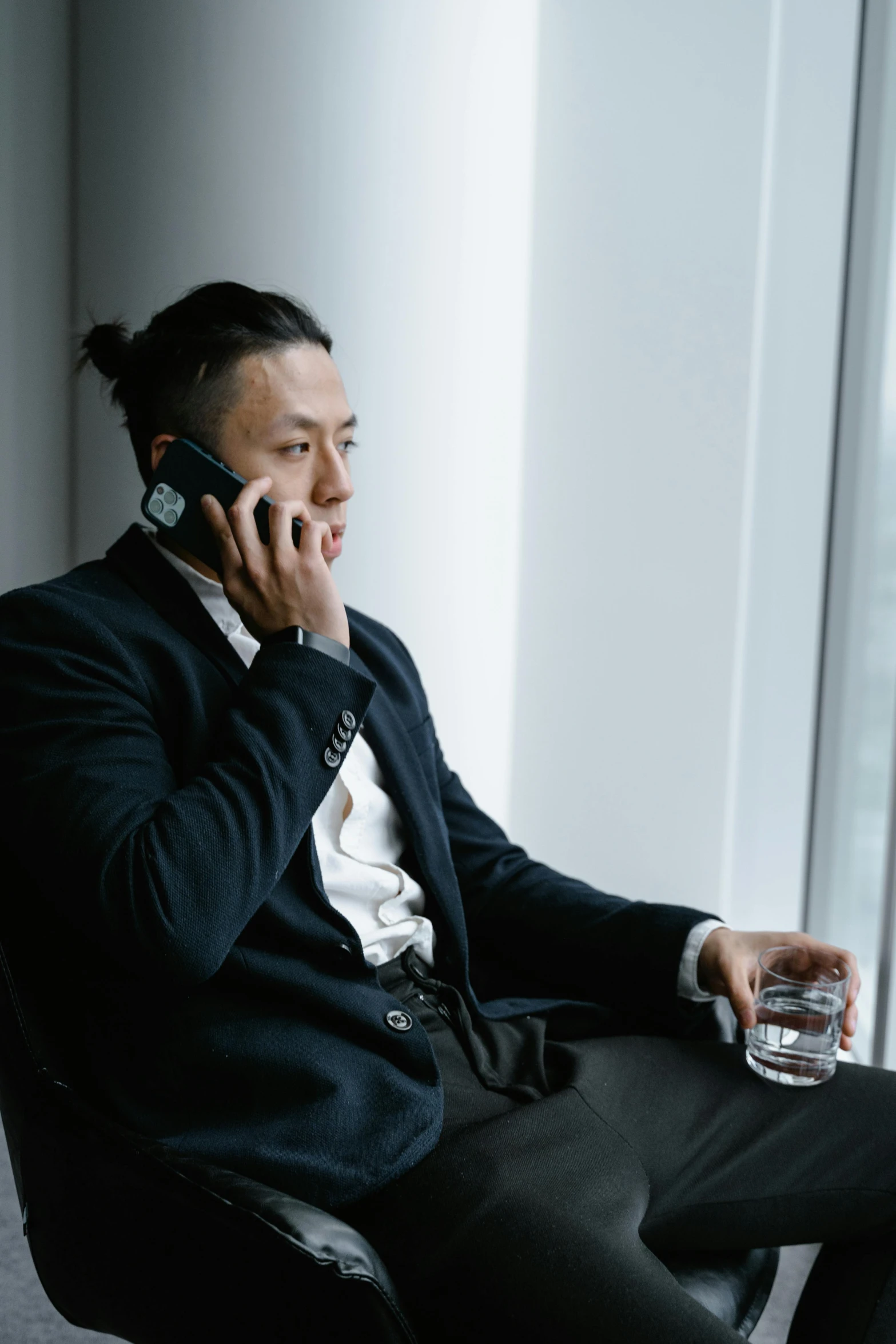 a man sitting in a chair and talking on a cellphone