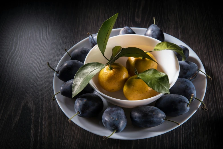 a white plate holding a bowl filled with oranges