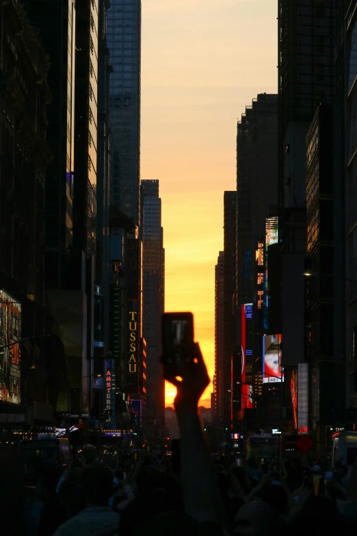 a crowd stands in the middle of a city street