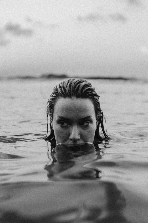 the head and shoulders of a man with long hair submerged in the water