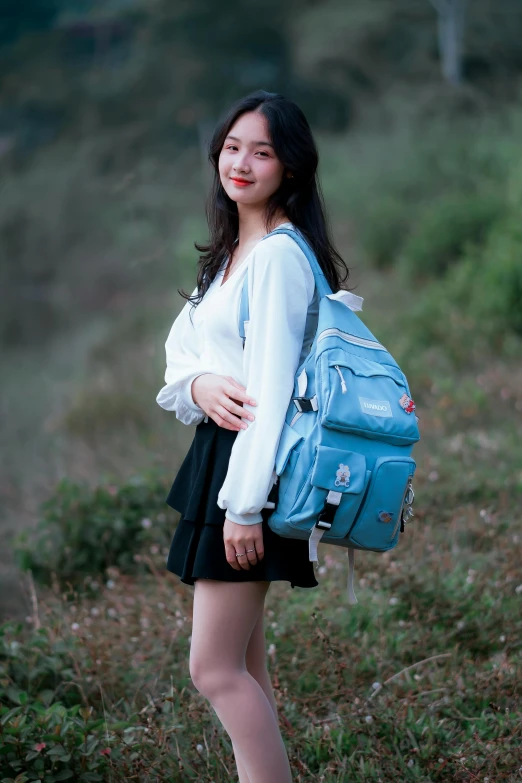 a woman in a white shirt and a blue backpack