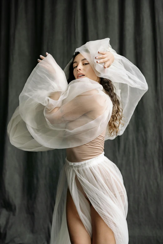 a woman in a dress poses with her arms spread