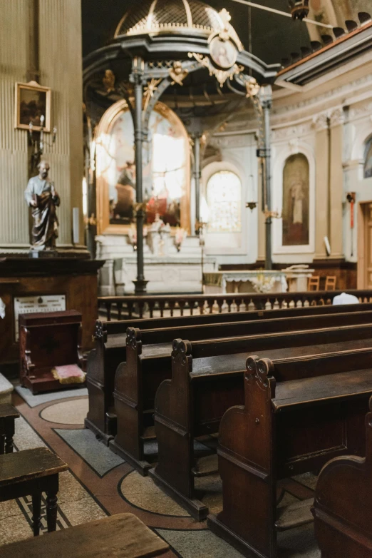empty pews in an ornate church with paintings and sculptures