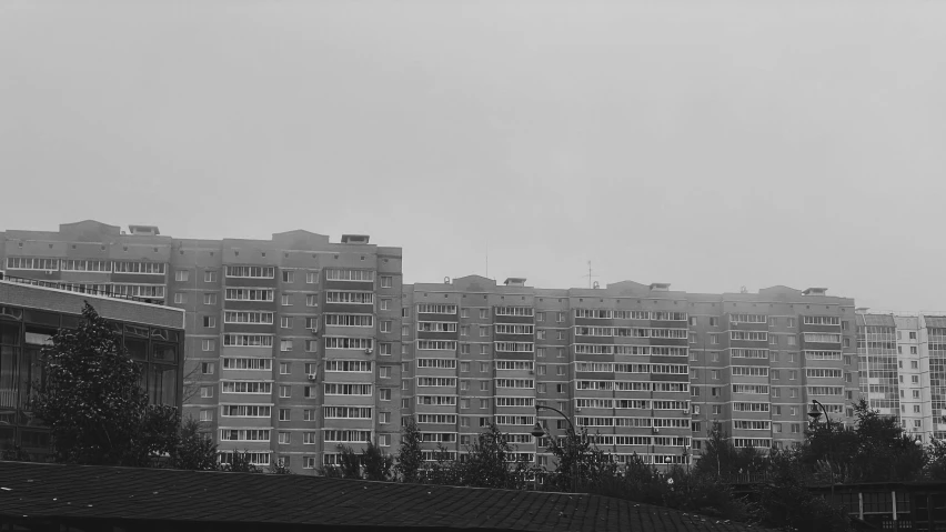 several tall buildings with trees in the foreground