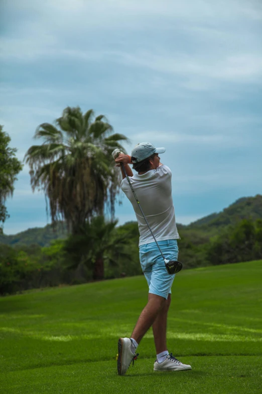 a person swinging a golf club in a field