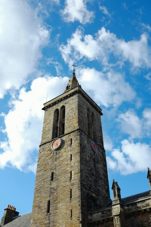 a stone building with a clock and tower below