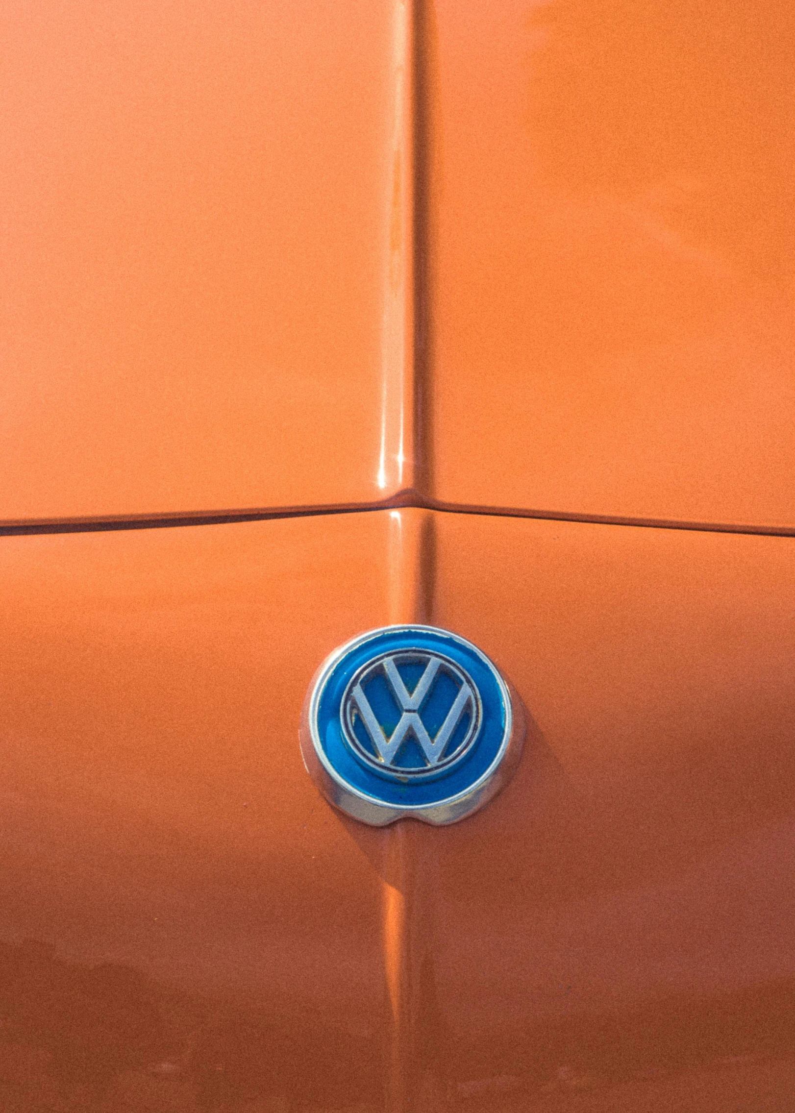 a close up of the emblem of an orange volkswagen car