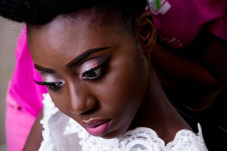 a woman in white wears pink and black makeup