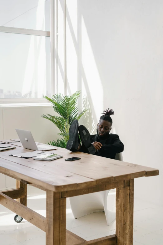 a woman sitting at a desk with her laptop and coffee