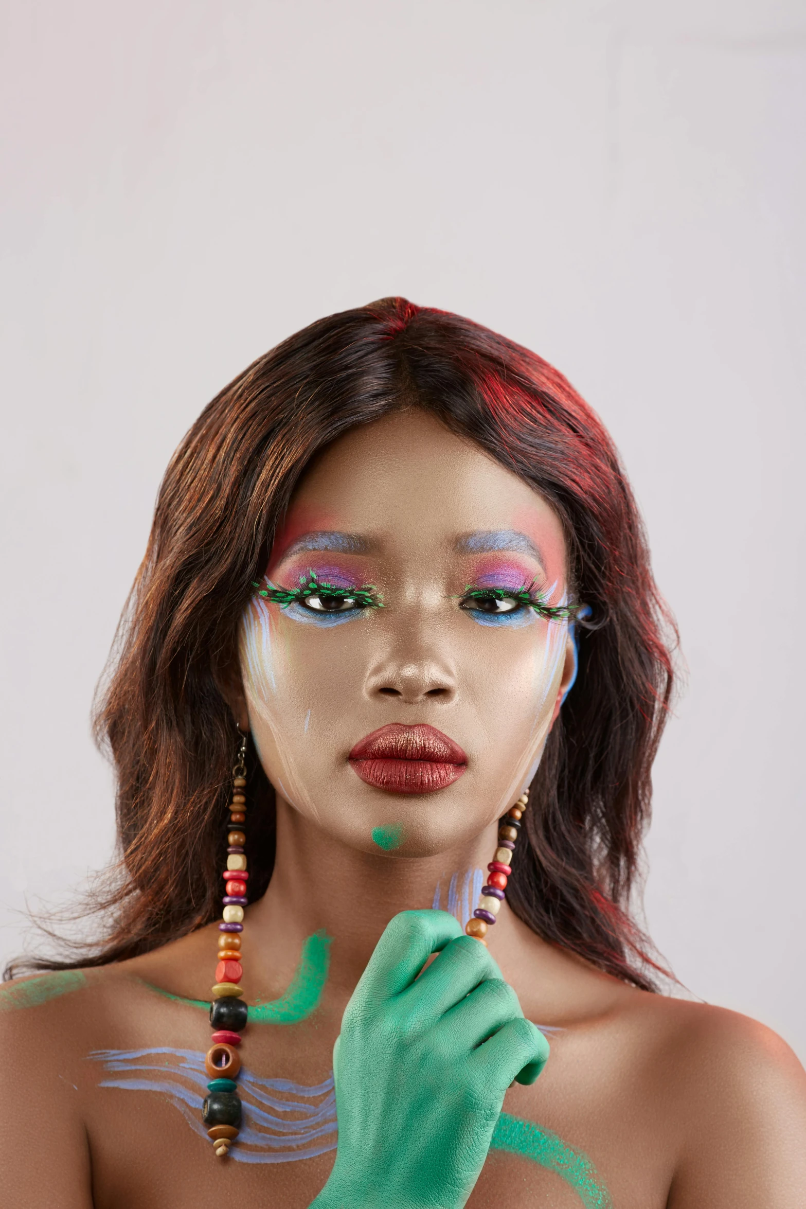 a woman with face painted as a feather and some beads