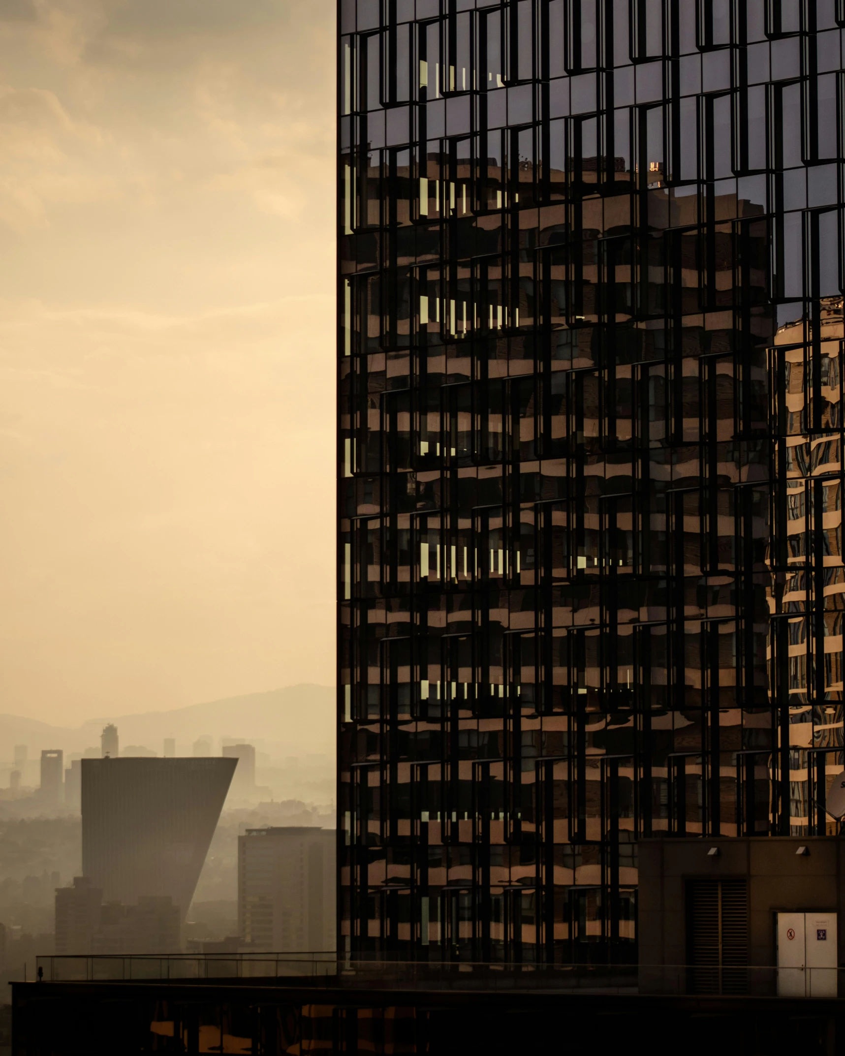 a skyscr with several windows and buildings in the background