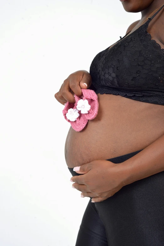 a pregnant woman in tights with her belly covered by a large flower