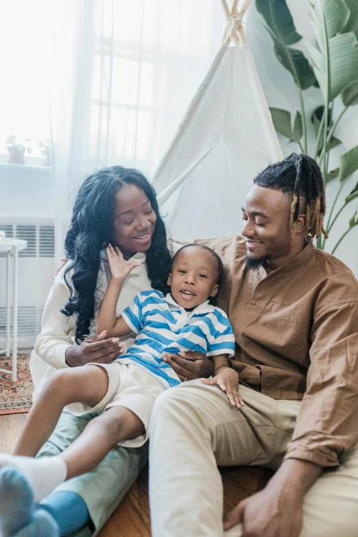 a family sits together on the floor of their living room