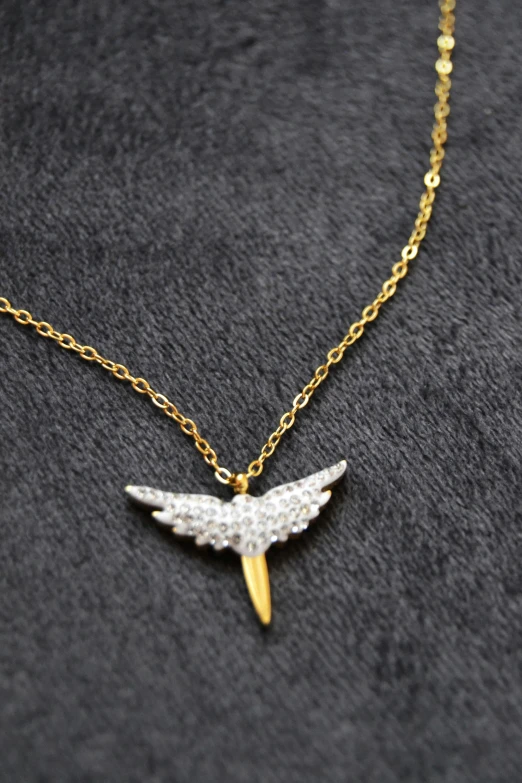 necklace featuring a gold plated bird pendant with swaroons