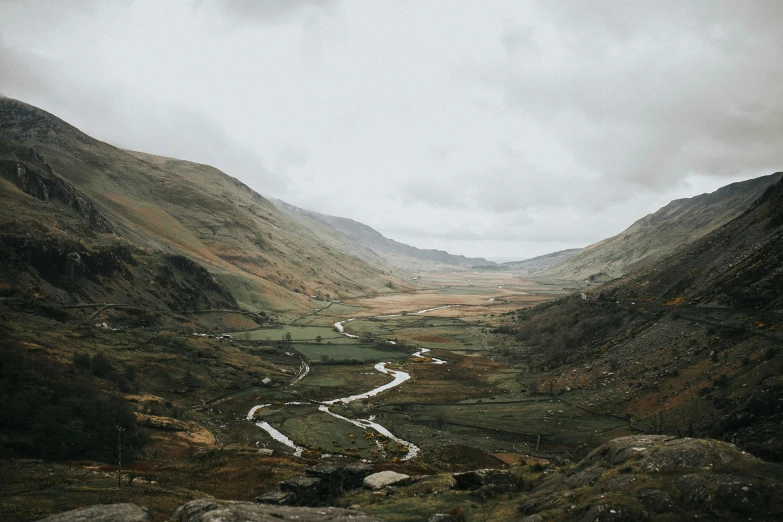 a road in the mountains with a few vehicles going around