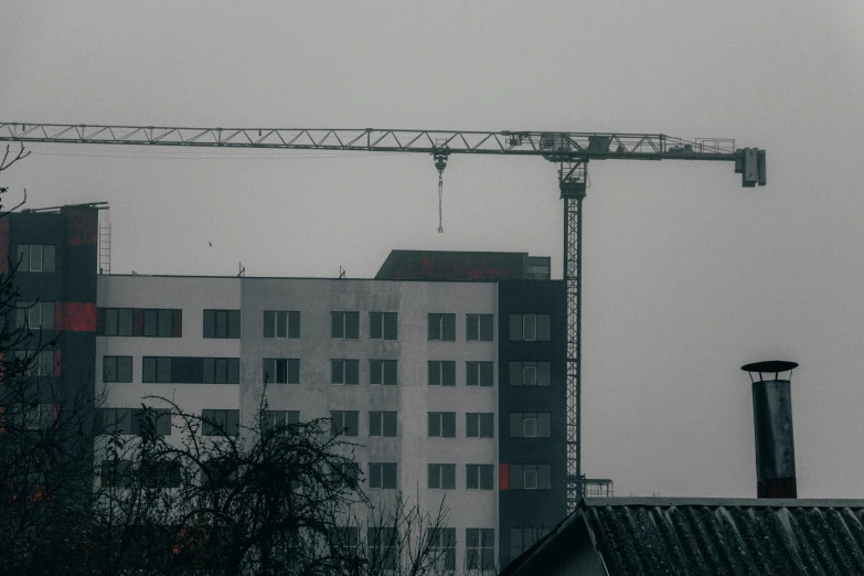 an urban building is shown behind a tower crane