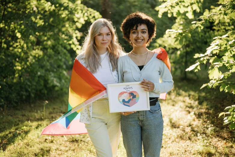 two women carrying flags walk in the woods