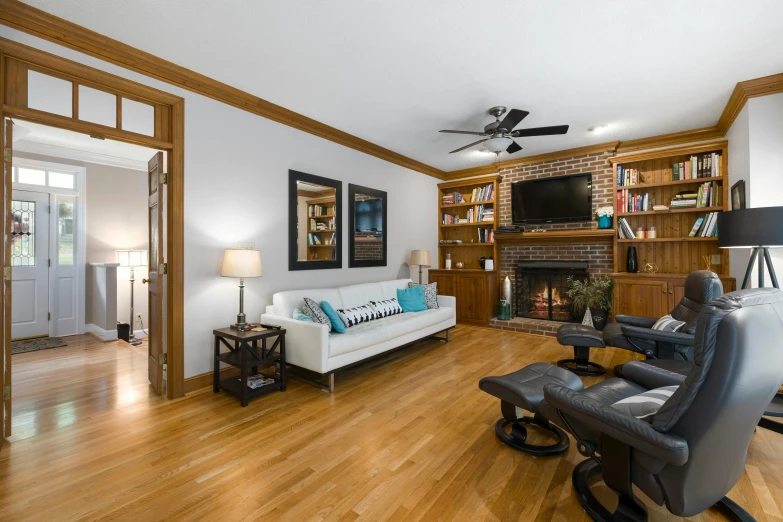 a den with furniture, bookcases and pictures on the wall