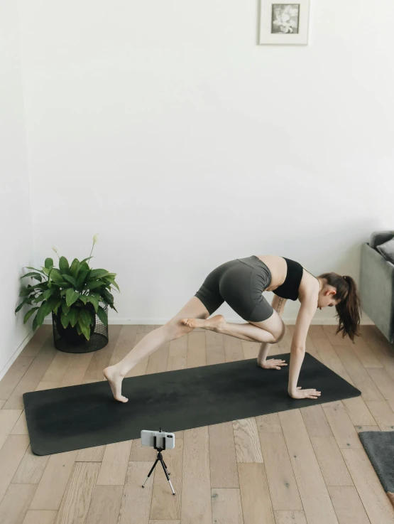 woman standing on an exercise mat in a yoga pose